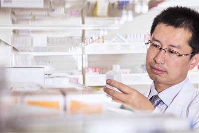 Pharmacist taking down and examining prescription medication